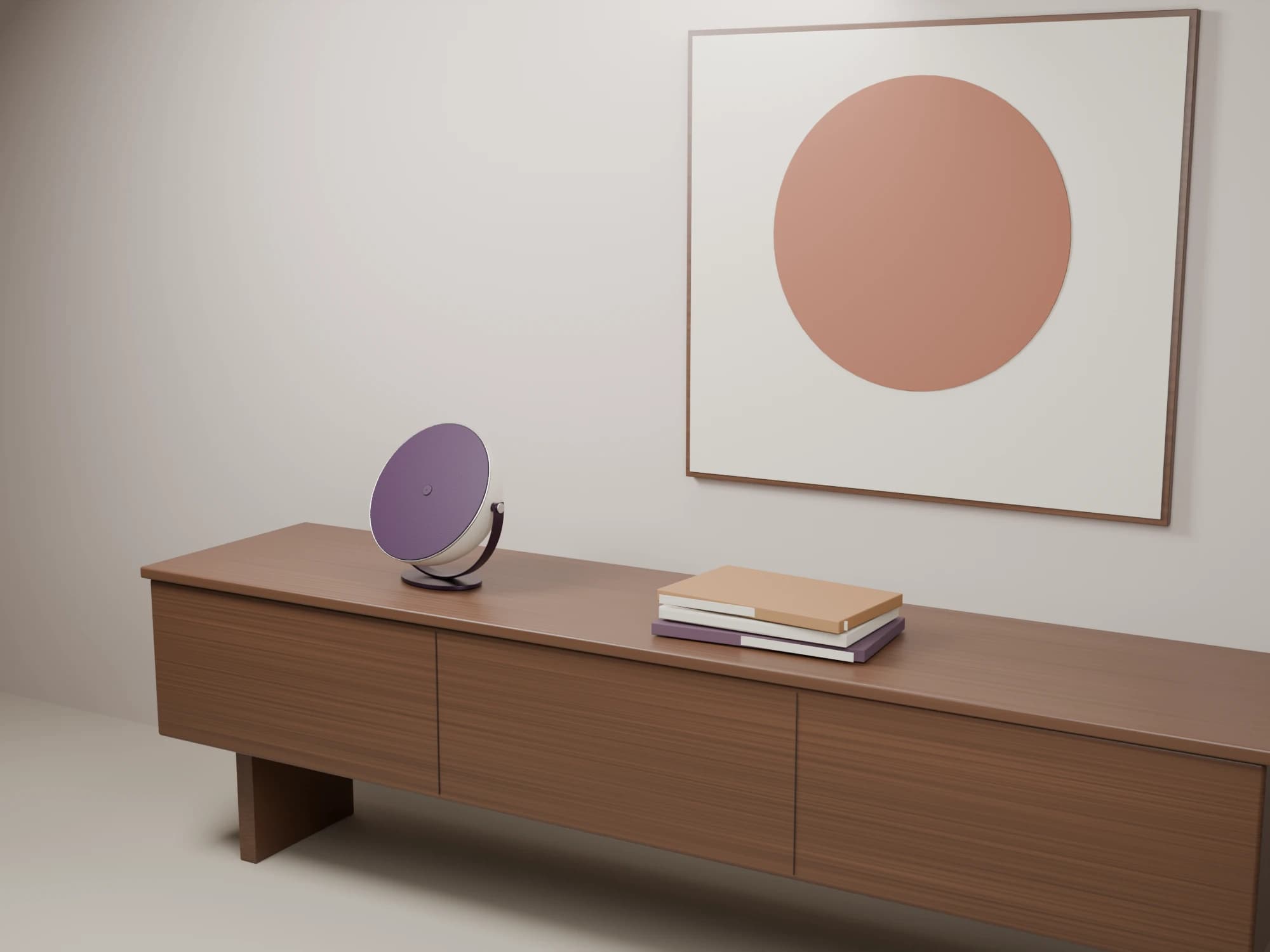 Orbit Cradle on a walnut console beside books, beneath a framed circular artwork